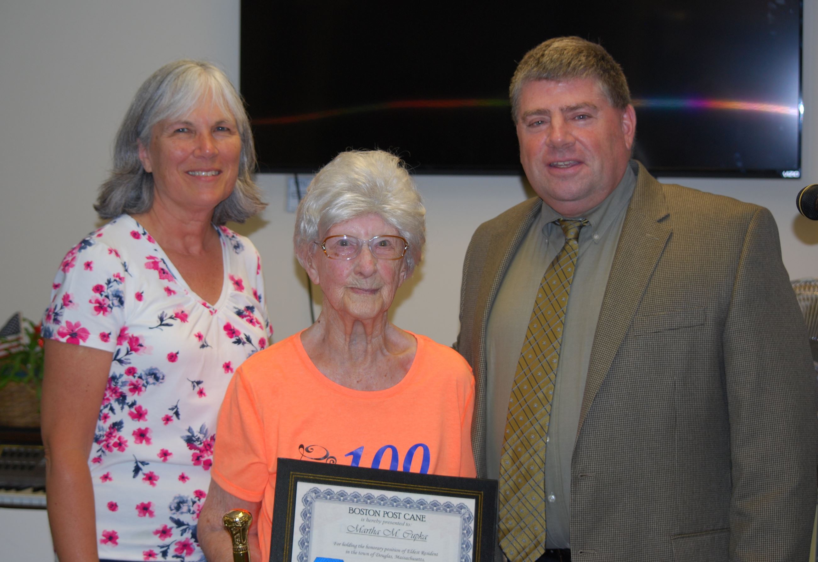 Selectman Cortese, and Suzanne Kane, present Boston Post Cane certificate to Martha Chupka